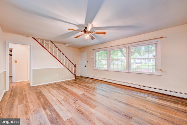 107 Juniper Dr, Levittown, PA 19056 - unfurnished living room with light wood-type flooring, baseboards, baseboard heating, ceiling fan, and stairs