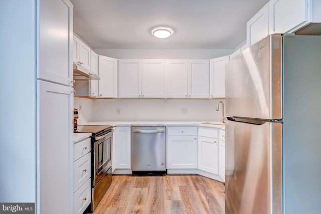 107 Juniper Dr, Levittown, PA 19056 - kitchen with light wood finished floors, stainless steel appliances, white cabinetry, under cabinet range hood, and light countertops