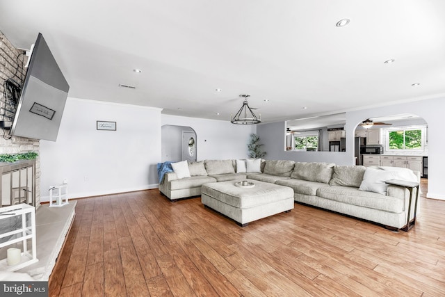 2031 Indian Cir, Saint Leonard, MD 20685 - living area with ornamental molding, a fireplace, arched walkways, a ceiling fan, and light wood-style floors