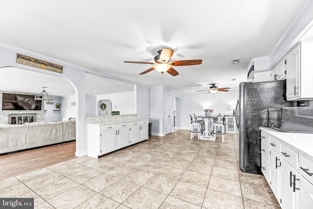 2031 Indian Cir, Saint Leonard, MD 20685 - kitchen featuring a ceiling fan, open floor plan, white cabinetry, arched walkways, and light tile patterned flooring