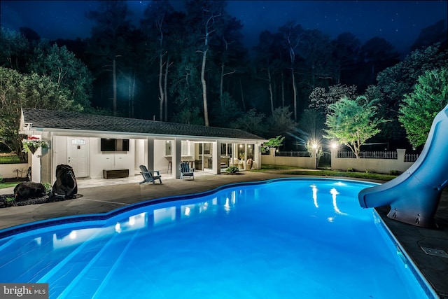 2031 Indian Cir, Saint Leonard, MD 20685 - pool at twilight featuring a fenced in pool, fence, a patio, a storage structure, and a water slide