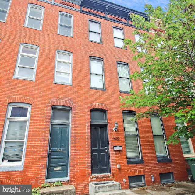 townhome / multi-family property with entry steps and brick siding