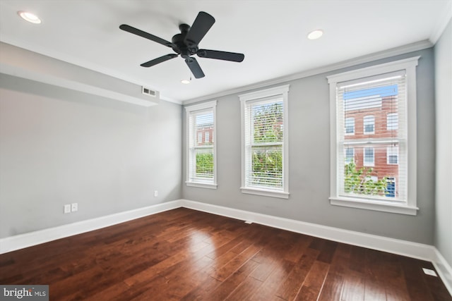 empty room with baseboards, crown molding, dark wood-type flooring, recessed lighting, and a ceiling fan