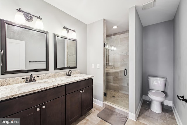 bathroom with baseboards, a stall shower, toilet, double vanity, and tile patterned flooring