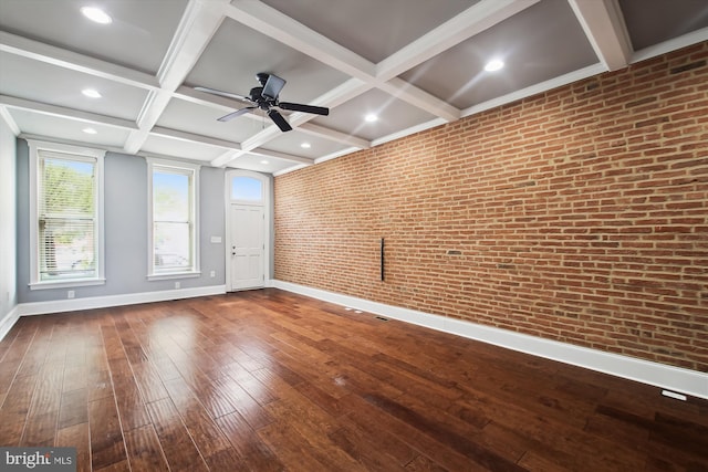 unfurnished room featuring baseboards, brick wall, coffered ceiling, dark wood-style flooring, and ceiling fan