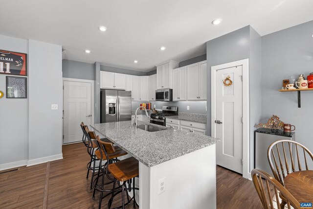 4286 Sunset Dr, Charlottesville, VA 22911 - kitchen featuring stainless steel appliances, a breakfast bar area, dark wood-style flooring, white cabinets, and light stone counters