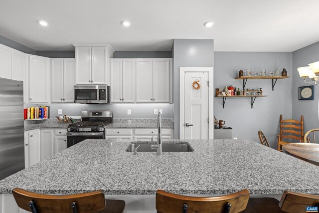 4286 Sunset Dr, Charlottesville, VA 22911 - kitchen featuring stainless steel appliances, a sink, a kitchen island with sink, a kitchen bar, and white cabinets