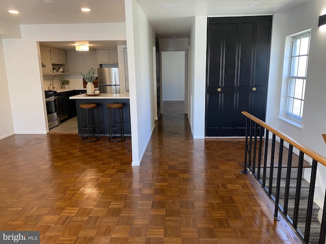 371 Old Forge Xing Unit 371, Devon, PA 19333 - kitchen with appliances with stainless steel finishes, baseboards, light countertops, a kitchen bar, and recessed lighting