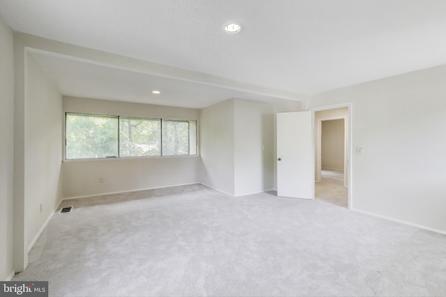 spare room with light colored carpet, baseboards, and recessed lighting