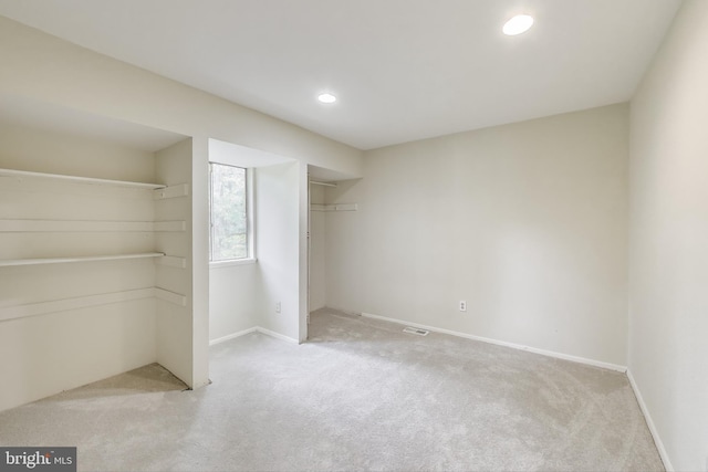 unfurnished bedroom with light carpet, recessed lighting, baseboards, and a closet