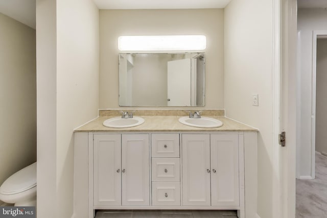 bathroom with double vanity and toilet