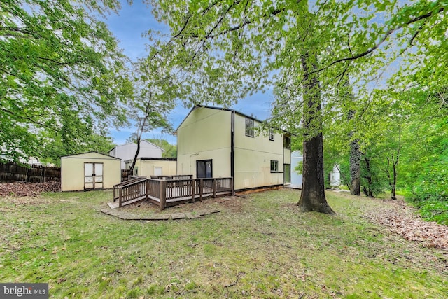 rear view of property featuring a shed, a deck, and an outdoor structure