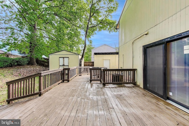 deck featuring a storage shed, an outdoor structure, and a fenced backyard