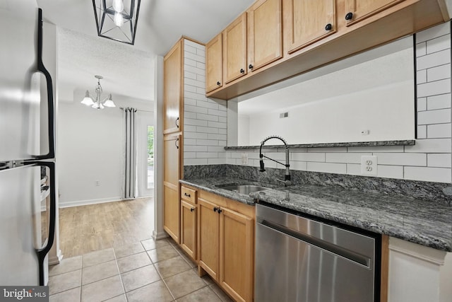 15645 Horseshoe Ln, Woodbridge, VA 22191 - kitchen with a sink, stainless steel appliances, an inviting chandelier, backsplash, and light tile patterned floors