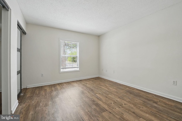 15645 Horseshoe Ln, Woodbridge, VA 22191 - unfurnished bedroom featuring dark wood-style flooring, a textured ceiling, and baseboards