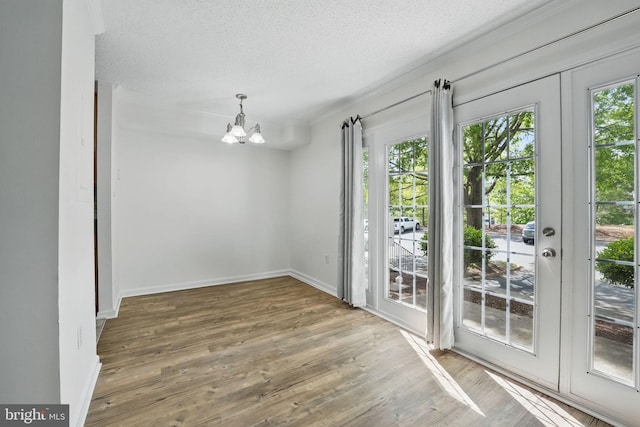 15645 Horseshoe Ln, Woodbridge, VA 22191 - unfurnished dining area featuring an inviting chandelier, a wealth of natural light, wood finished floors, and a textured ceiling