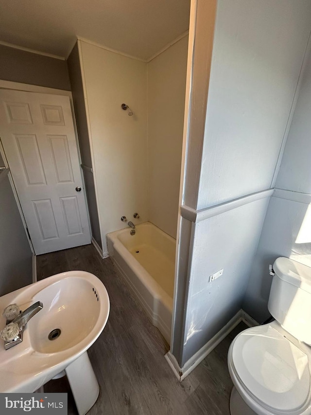 bathroom with wood finished floors, toilet, and a sink