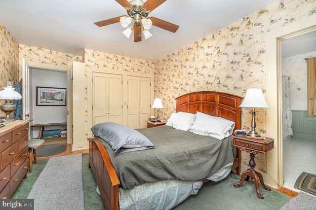 bedroom with carpet, wallpapered walls, a closet, ensuite bathroom, and ceiling fan