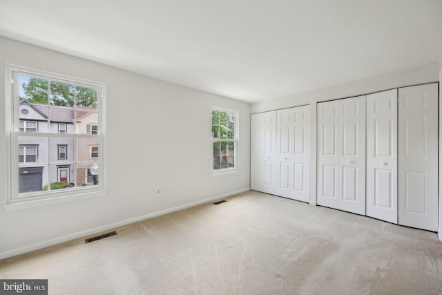 2327 London Bridge Dr, Silver Spring, MD 20906 - unfurnished bedroom with multiple closets, carpet floors, multiple windows, and baseboards