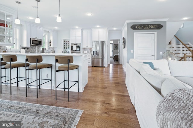 23336 Horse Island Rd, Lewes, DE 19958 - kitchen featuring a peninsula, stainless steel appliances, tasteful backsplash, a breakfast bar area, and glass insert cabinets