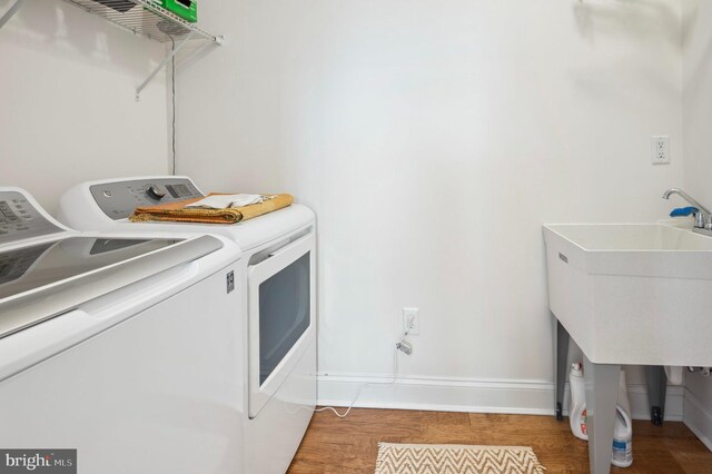 23336 Horse Island Rd, Lewes, DE 19958 - clothes washing area featuring washing machine and clothes dryer, baseboards, laundry area, and wood finished floors