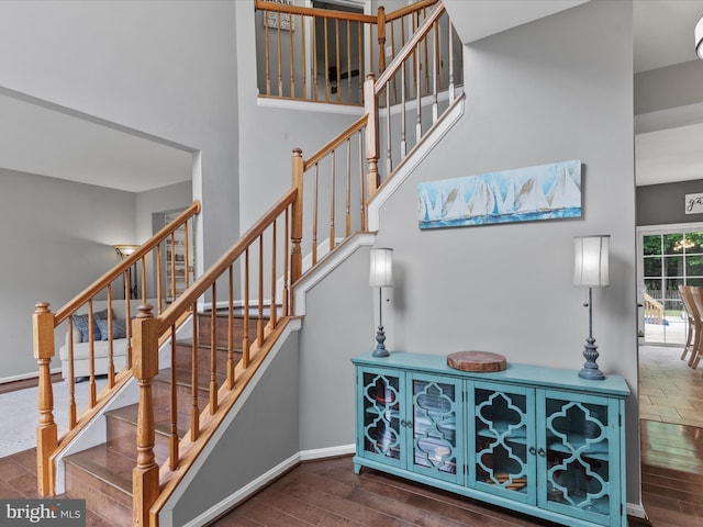 33759 Bay Ridge Ln, Lewes, DE 19958 - stairway featuring wood finished floors, a high ceiling, and baseboards