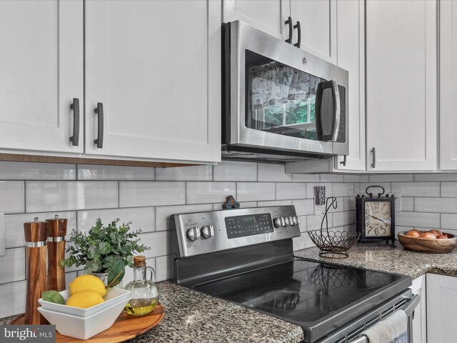33759 Bay Ridge Ln, Lewes, DE 19958 - kitchen with appliances with stainless steel finishes, white cabinets, and tasteful backsplash