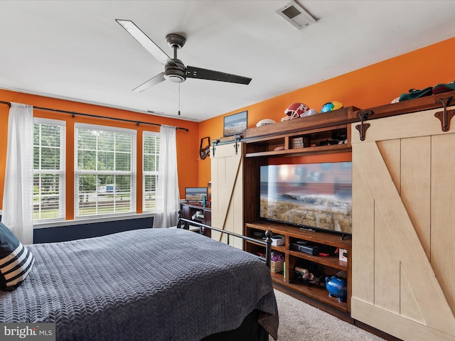 33759 Bay Ridge Ln, Lewes, DE 19958 - bedroom featuring a barn door, wood finished floors, and a ceiling fan