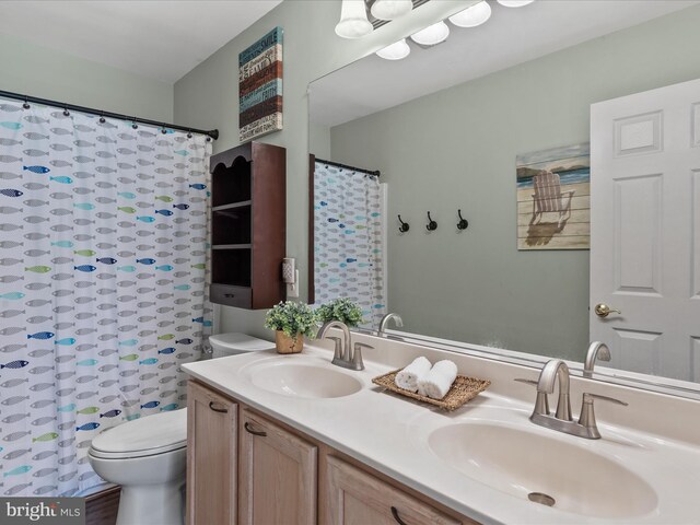 33759 Bay Ridge Ln, Lewes, DE 19958 - full bathroom featuring toilet, double vanity, and a shower with shower curtain