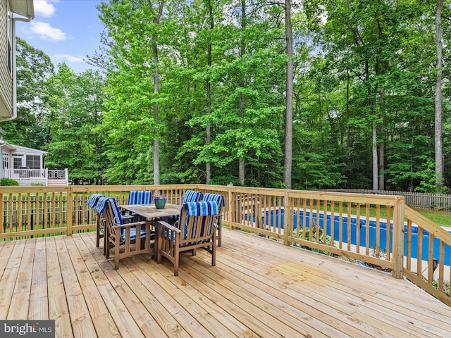 33759 Bay Ridge Ln, Lewes, DE 19958 - wooden terrace featuring outdoor dining space and view of wooded area