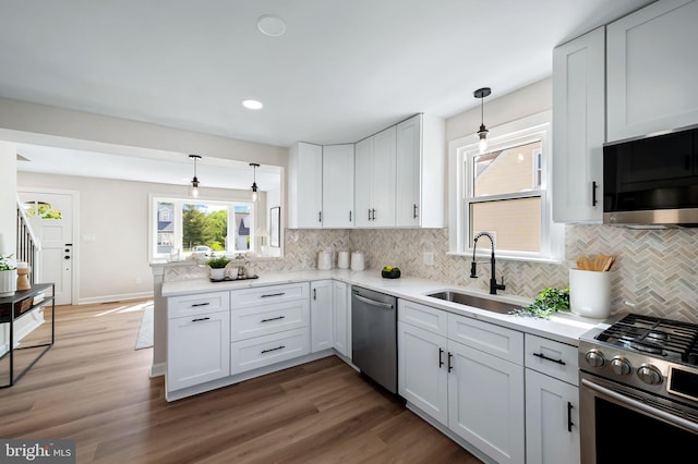 1233 Kendrick Rd, Rosedale, MD 21237 - kitchen featuring appliances with stainless steel finishes, a sink, tasteful backsplash, light countertops, and wood finished floors