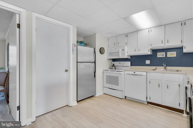 6 141st St Unit 304, Ocean City, MD 21842 - kitchen with white appliances, a paneled ceiling, a sink, white cabinets, and light countertops