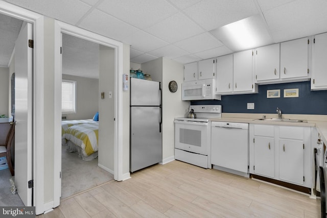 6 141st St Unit 304, Ocean City, MD 21842 - kitchen featuring white appliances, a sink, light wood-style flooring, light countertops, and white cabinetry
