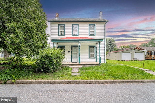 614 W Front St, Marietta, PA 17547 - view of front of house featuring a chimney, covered porch, a yard, an outdoor structure, and a detached garage