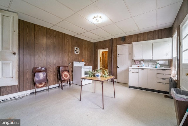 614 W Front St, Marietta, PA 17547 - kitchen with white gas range oven, wooden walls, white cabinets, light countertops, and washer / dryer