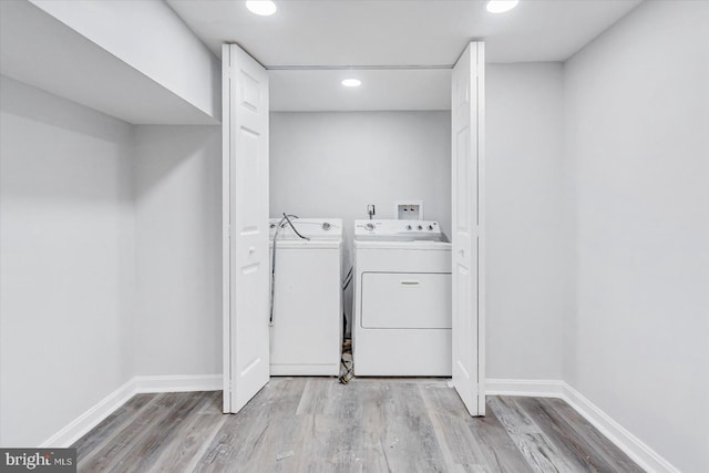clothes washing area featuring washing machine and dryer, light wood finished floors, baseboards, and recessed lighting