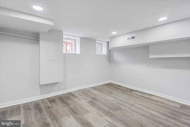 basement with baseboards, wood finished floors, and recessed lighting