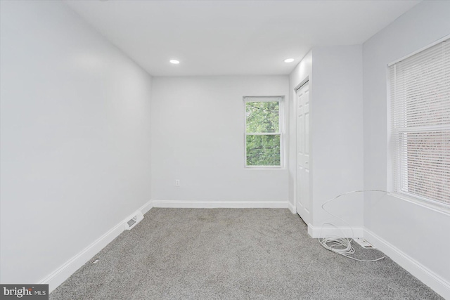 carpeted empty room featuring baseboards and recessed lighting