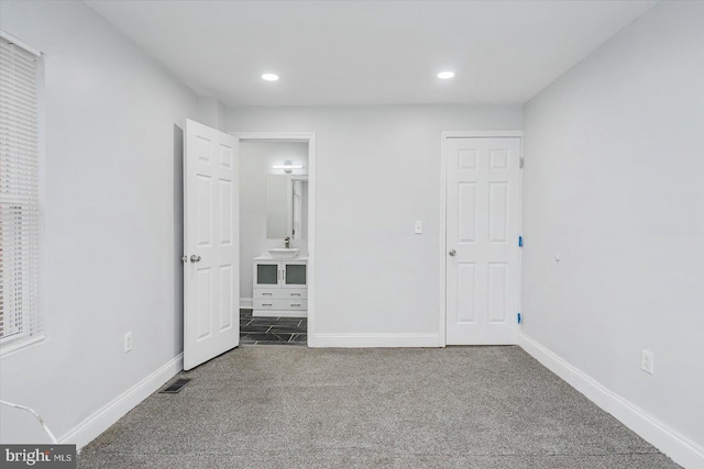 unfurnished bedroom featuring carpet flooring, baseboards, recessed lighting, and connected bathroom