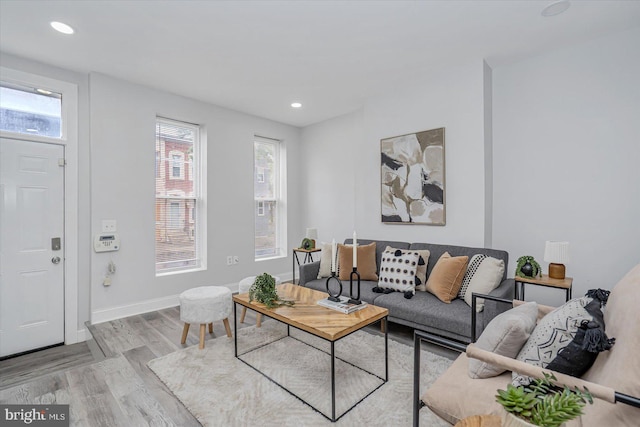 living room with wood finished floors, baseboards, and recessed lighting