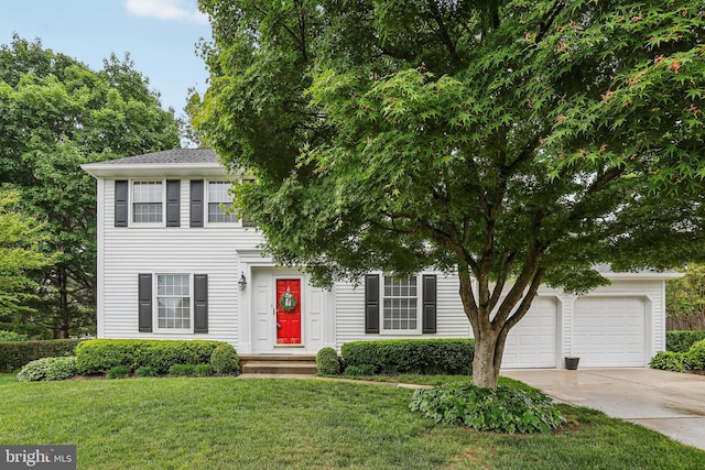 view of front of house with concrete driveway, a garage, and a front lawn