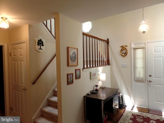 foyer entrance featuring stairs and wood finished floors