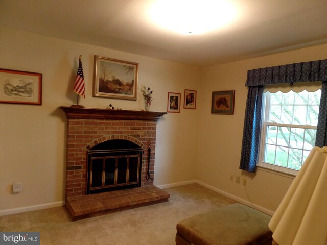 carpeted living room featuring baseboards and a brick fireplace