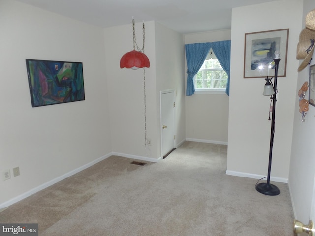 spare room featuring carpet flooring and baseboards