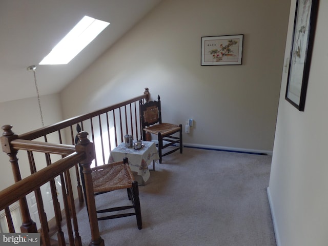 hallway with vaulted ceiling, a skylight, and carpet
