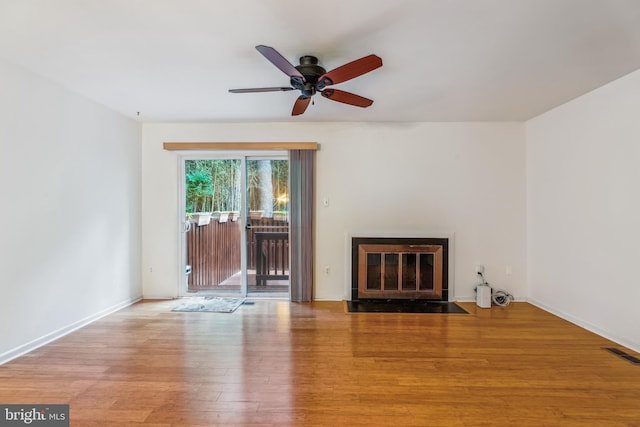 1211 Hesselius Ct, Annapolis, MD 21403 - unfurnished living room featuring a ceiling fan, a fireplace with flush hearth, wood finished floors, and baseboards