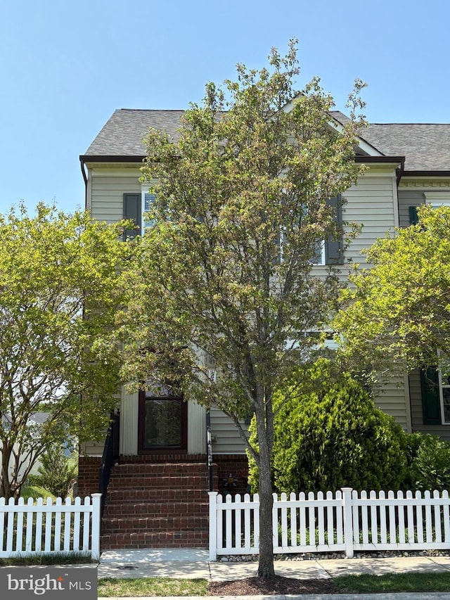 206 Village Center Blvd, Milton, DE 19968 - view of property hidden behind natural elements with a fenced front yard, brick siding, and entry steps