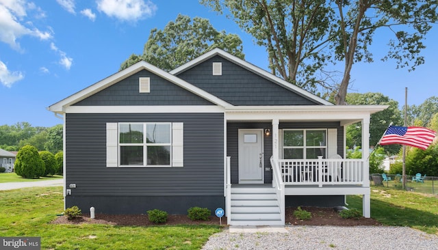 bungalow-style home with a front yard and covered porch