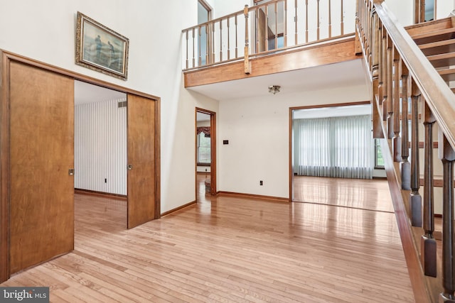 237 Bordentown-Georgetown Rd, Chesterfield, NJ 08515 - unfurnished living room with hardwood / wood-style flooring, stairs, a high ceiling, and baseboards