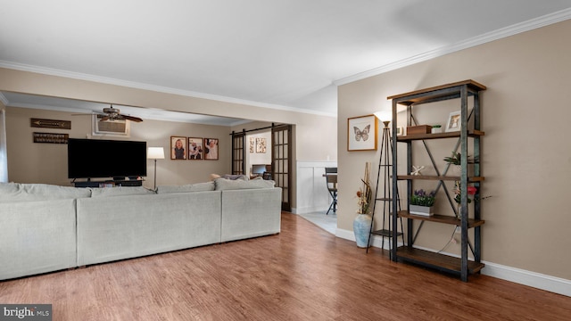 10 Queen Lily Rd, Levittown, PA 19057 - living area featuring a barn door, ceiling fan, crown molding, wood finished floors, and baseboards